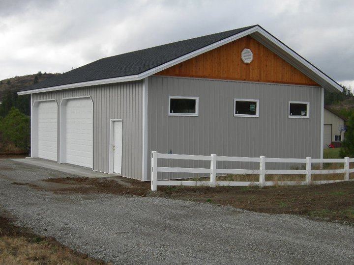 Residential storage garage with white fencing